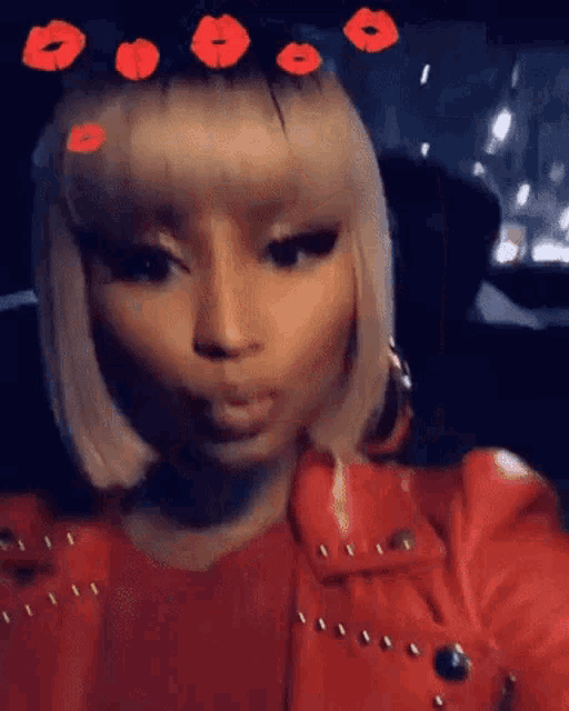 a woman in a red jacket is taking a selfie in a car with red lips on her head .