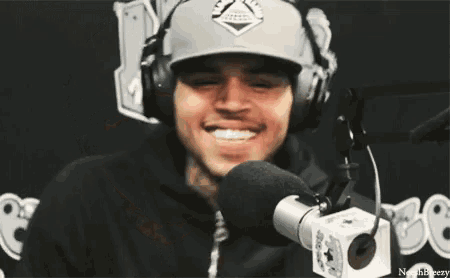 a man wearing headphones is sticking his tongue out in front of a microphone