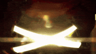 a light that looks like a cross is coming out of a dark background
