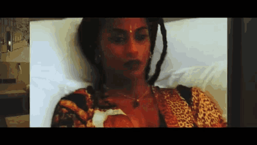 a woman in a leopard print shirt is laying in a hospital bed