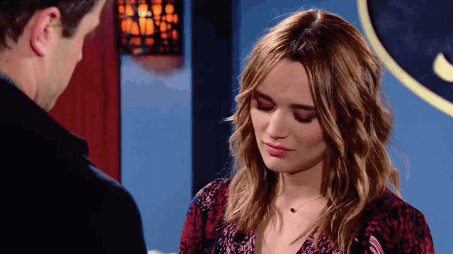 a man and a woman are looking at each other and the woman is wearing a leopard print top