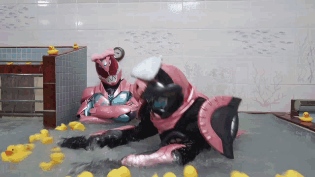 a couple of rubber ducks are floating in a bathtub with a superhero