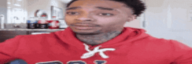 a man in a red hoodie is making a face .