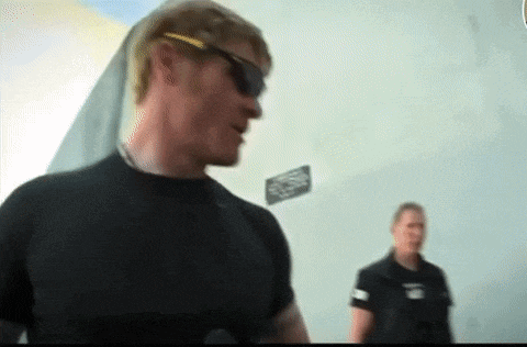 a man wearing sunglasses and a black shirt is standing next to a man wearing a black shirt .