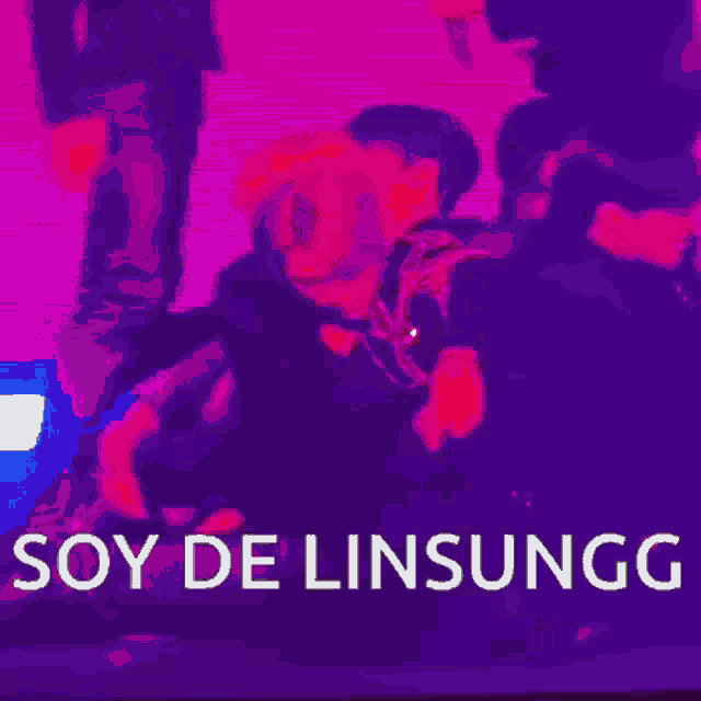 a man in a black jacket is dancing in a dark room with the words soy de linsungg written on the bottom .
