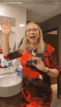 a woman in a red dress is standing in front of a bathroom sink with a search bar that says find related content on it