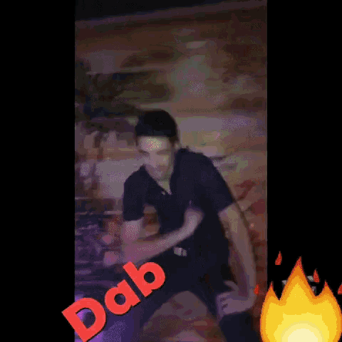 a man in a black shirt is dancing in front of a wall that says dab