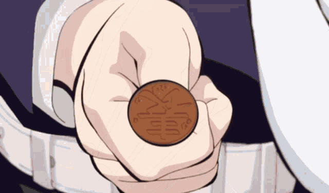 a person is holding a coin in their hand with chinese characters on it
