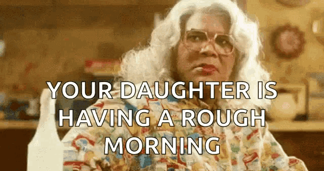a woman in a wig and glasses is sitting in a kitchen with the words `` your daughter is having a rough morning ''