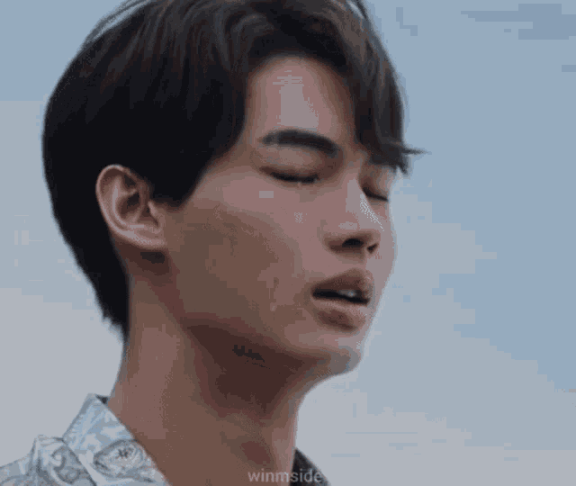 a close up of a young man 's face with his eyes closed .