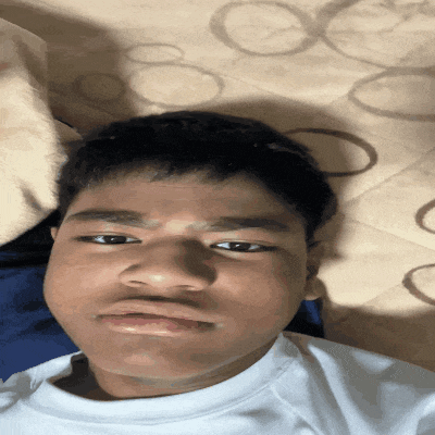 a young man laying on a bed with circles on the blanket