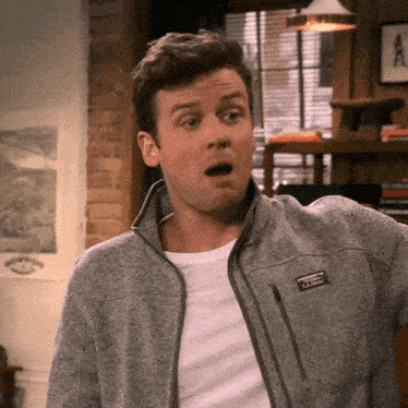 a man wearing a gray ll bean jacket looks surprised
