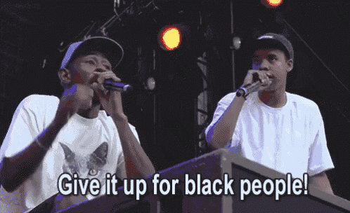 a man singing into a microphone with the words give it up for black people written below him