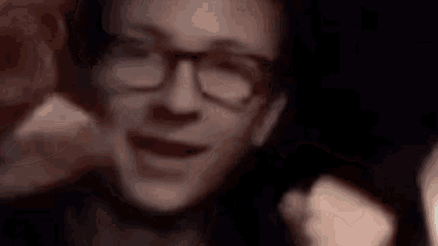 a close up of a man wearing glasses making a face .