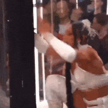 a woman in a white dress is being kissed by a man in a white shirt .