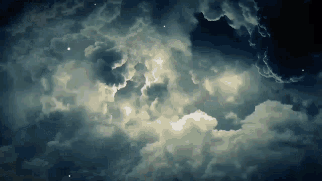 a cloudy night sky with a few stars in it