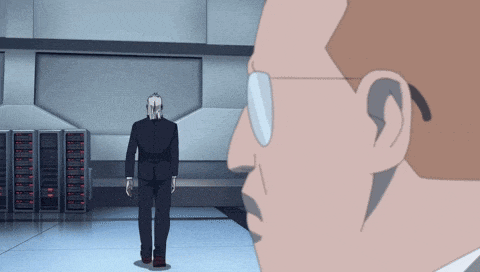 a man in a suit and glasses stands next to another man in a room
