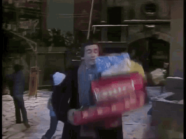 a man is carrying a bag of chips and bottles of water .