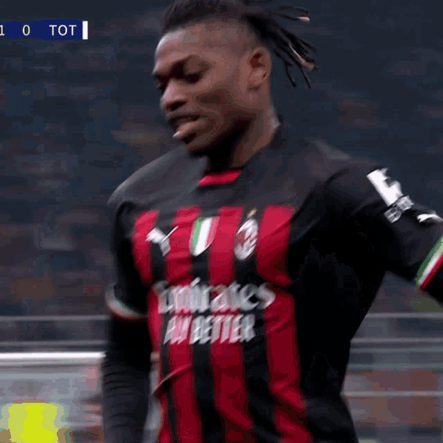 a soccer player wearing a red and black jersey with emirates fly better on it