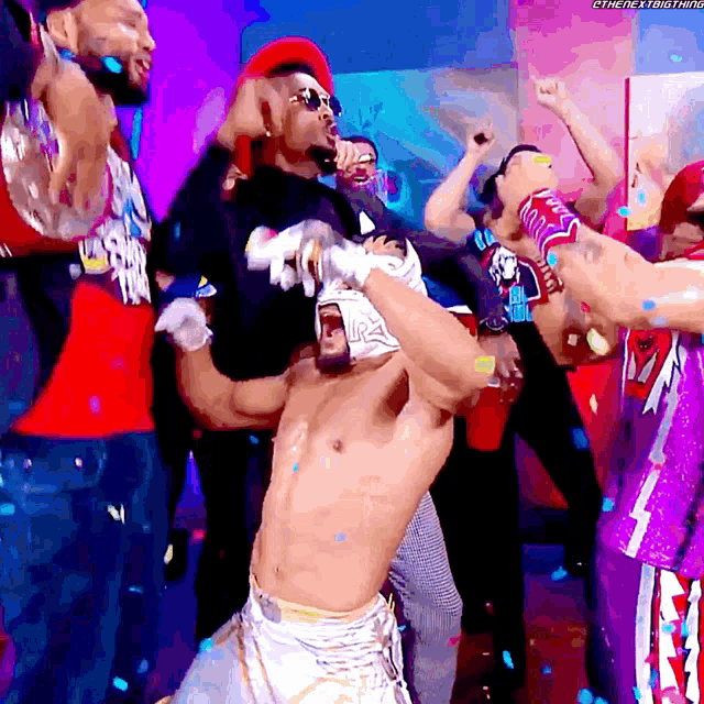 a shirtless wrestler is surrounded by a crowd and confetti while wearing a mask with the word lucha libre on it