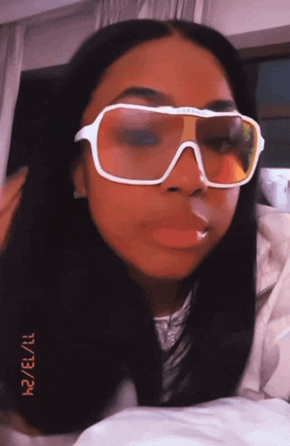a woman wearing a pair of sunglasses with the date 11/13/11 on the bottom