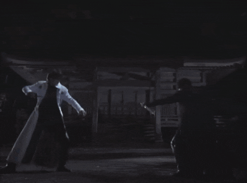 a man and a woman are dancing in a dark room with a circle of lights behind them