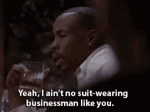 a man is drinking a glass of whiskey and saying yeah i ain 't no suit wearing businessman