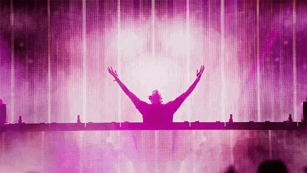 a dj with his arms outstretched in front of a pink backdrop