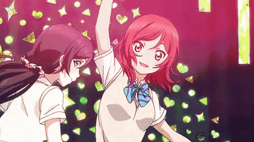 two anime girls are standing next to each other on a stage and dancing .