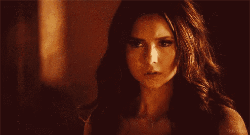 a close up of a woman 's face with long dark hair and a serious look on her face .