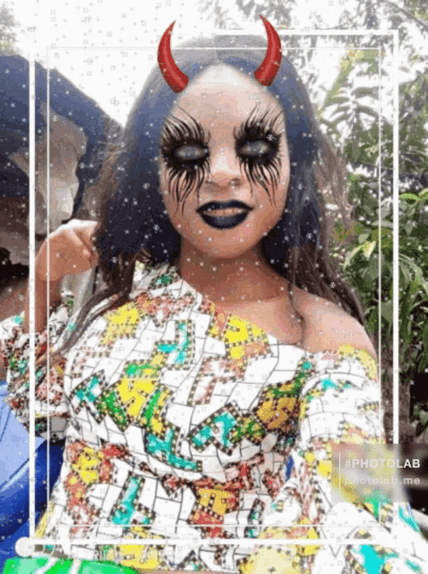 a woman with devil horns painted on her face is taking a selfie