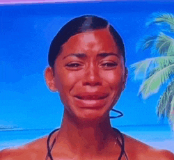 a woman in a bikini is crying in front of a beach .