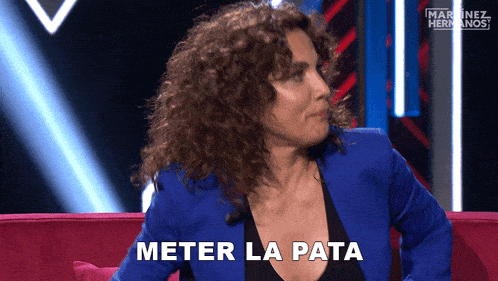 a woman in a blue jacket is sitting on a red couch and says meter la pata