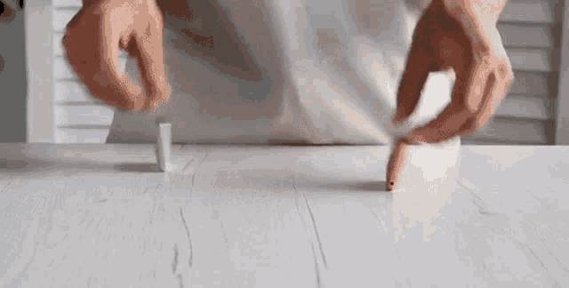 a person is holding a piece of paper on a table .