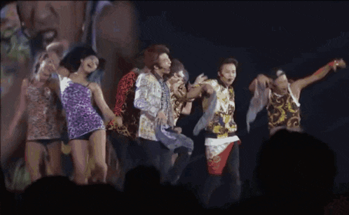 a group of people are dancing together on stage
