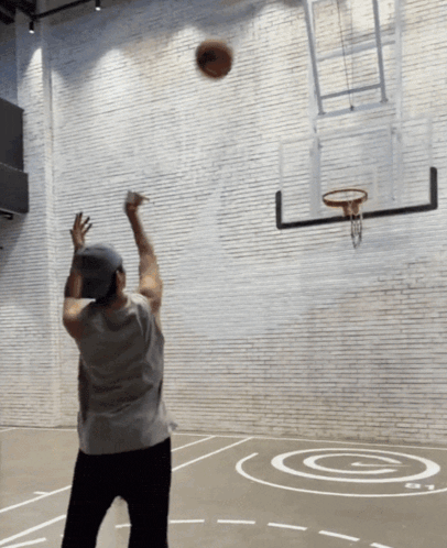 a man is throwing a basketball at a hoop