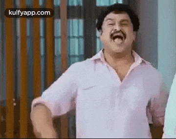 a man with a mustache is making a funny face and laughing .