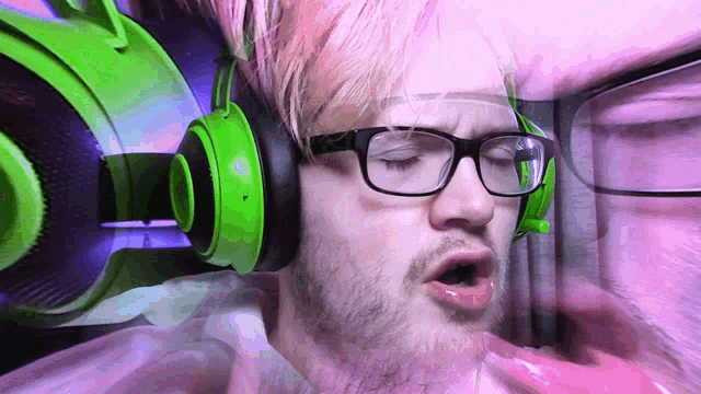 a man wearing glasses and green headphones is making a face