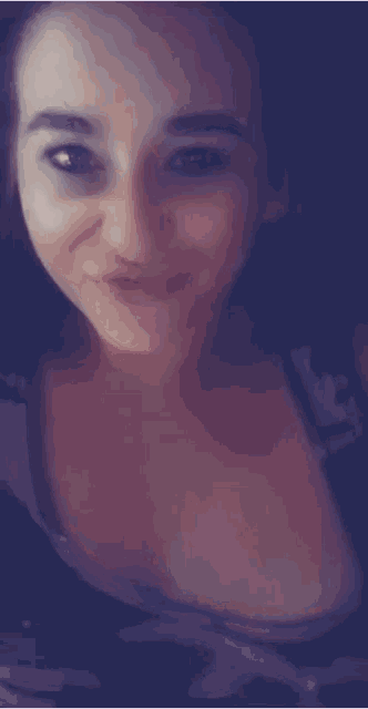 a close up of a woman 's face with a purple shirt