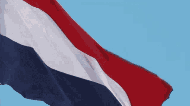 a red white and blue flag waving in the wind