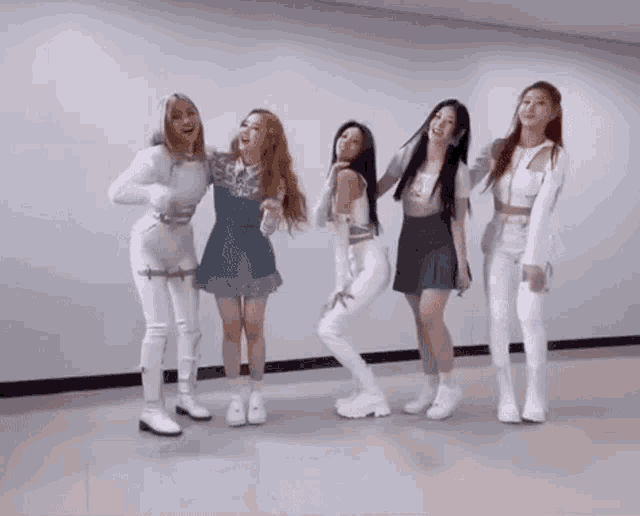 a group of girls are standing next to each other in a room .