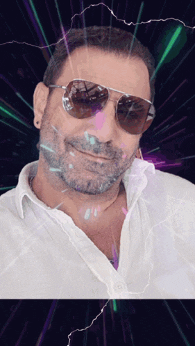 a man wearing sunglasses and a white shirt smiles for the camera