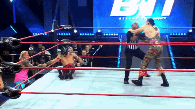 two wrestlers are in a wrestling ring with the word impact on the screen
