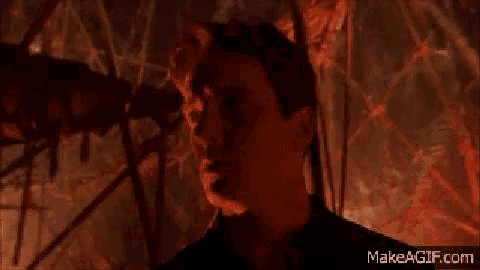 a man is standing in front of a burning forest with the words `` welcome '' written on the screen .