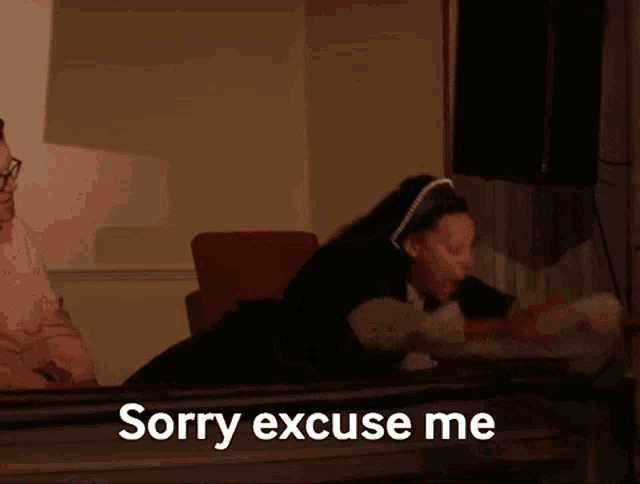 a woman says sorry excuse me while a man sits behind her