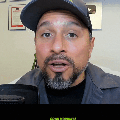 a man with a beard is wearing a hat that says upgraded
