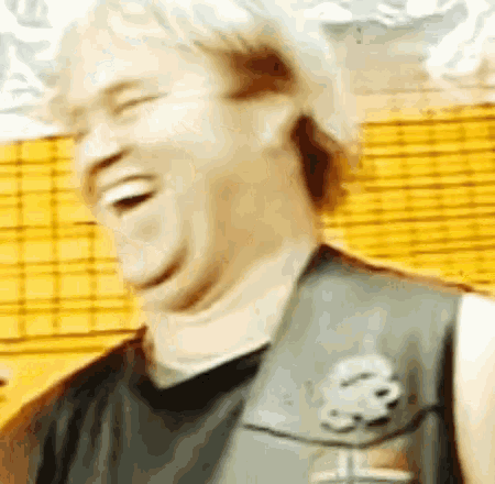a close up of a person laughing with a yellow background