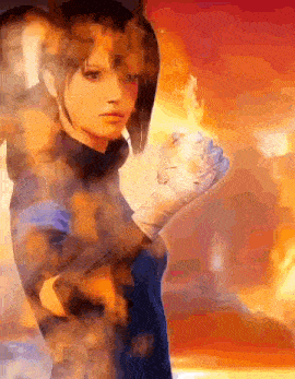 a woman is holding a fireball in her hand while standing in front of a fire .