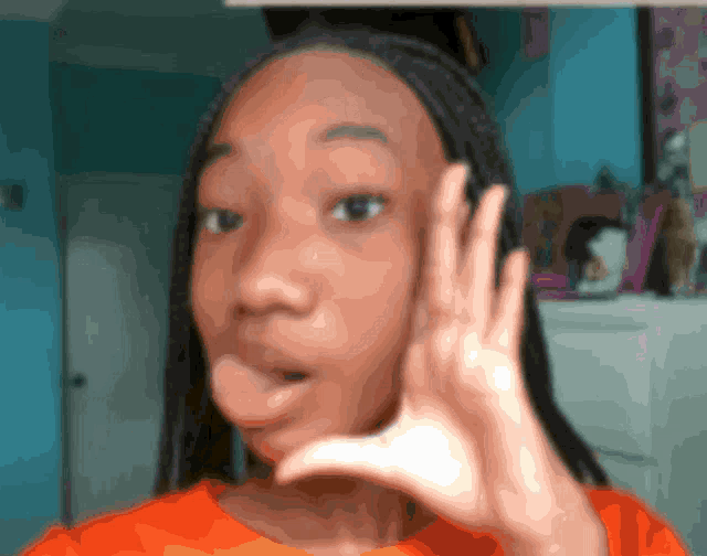 a girl with a surprised look on her face is holding her hand to her ear