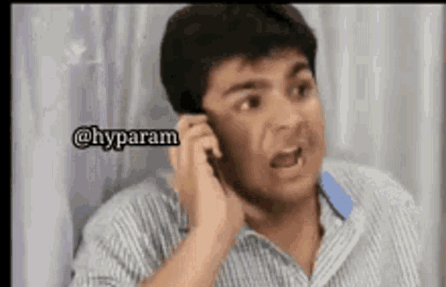 a man is talking on a cell phone and making a funny face